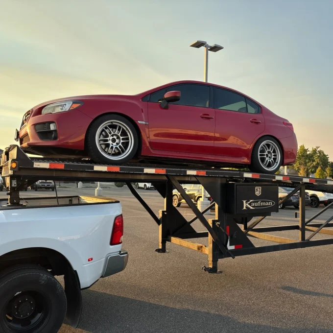 Professional car shipping service with vehicle loaded on auto transport trailer