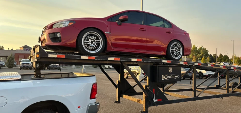 Professional car shipping service with vehicle loaded on auto transport trailer