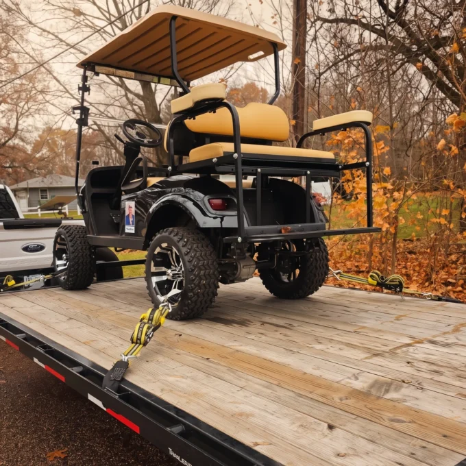 Custom golf cart loaded on a flatbed trailer being towed by a white Ford pickup truck by Your Xpert Trans